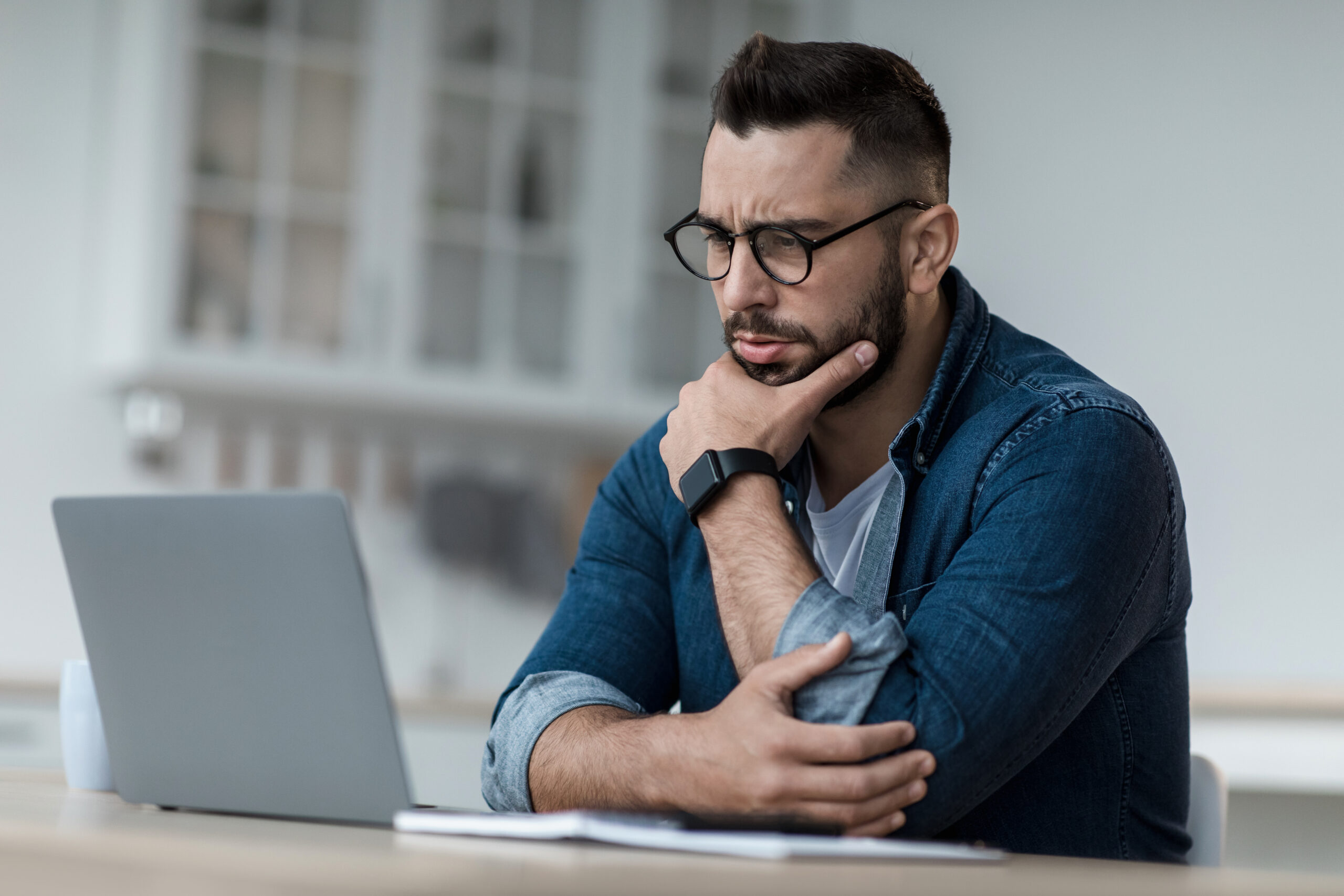 A young man professional looking at his laptop screen
